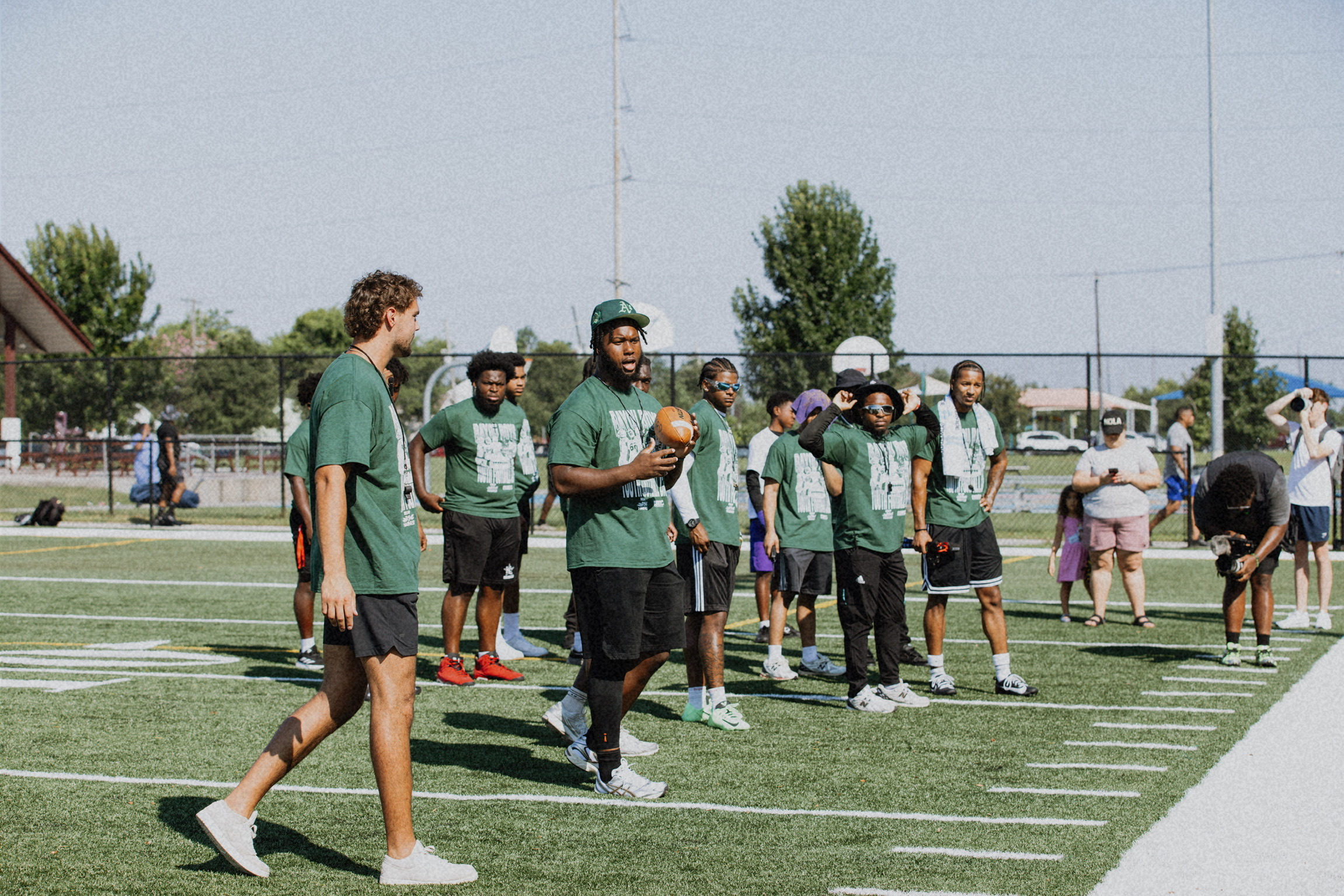 Coaches and kids on the football field at a Reap the Harvest camp
